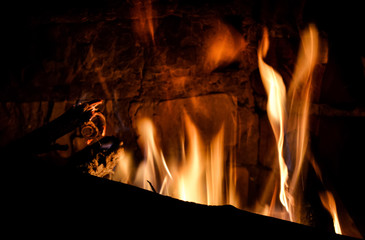 Closeup photo of blazing and warming fireplace in the cold evening.