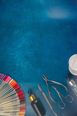 A set of cosmetic tools for manicure and pedicure on a blue background. Manicure scissors,...