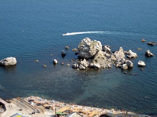 Beach and piles of stones in the sea near the shore.