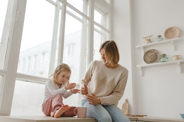 A young mother spends time with her little daughter at home.