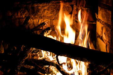 Closeup photo of blazing and warming fireplace in the cold evening.