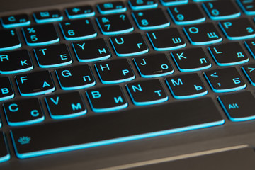 Close-up of laptop keyboard backlight, blue backlit keyboard.