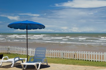 view of Barra dos Coqueiros beach with chair and umbrella, in Aracaju