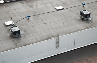 The external units of the commercial air conditioning and ventilation systems are installed on the roof of an industrial building. © vladk213