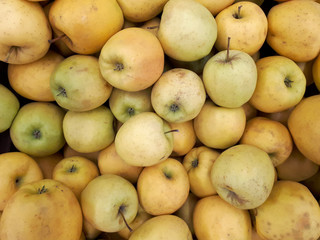 Apples in supermarket. Many ripe yellow apples, top view. Apples Golden, background