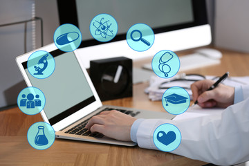 Medical student working with laptop indoors, closeup