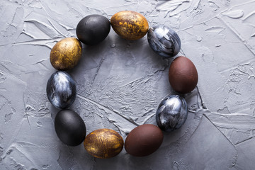 Holidays, traditions and Easter concept - Dark stylish easter eggs on grey background.