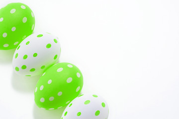 Easter eggs colored  green white decorated on white paper background. Happy Easter card with copy space for text. Minimal eco easter style.
