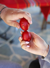 hands holding cracked red Easter eggs - Orthodox greek tradition of cracking eggs - symbolizes...
