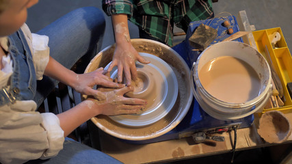 Slow motion, woman works with pottery wheel in a workshop