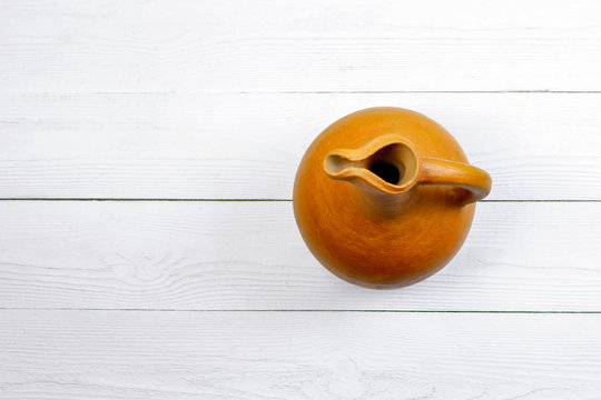 Georgian traditional clay wine jug &ndash; doki or doqi on white wooden background.  