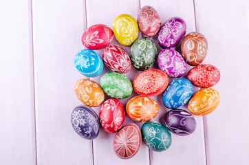 Variety of colorful handmade scratched easter eggs on wooden table