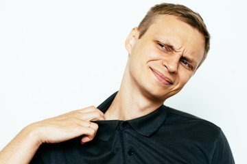 Closeup portrait of young man opening shirt to vent,it's hot. Negative emotion, facial expression,...
