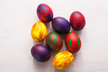 Holidays, traditions and Easter concept - Multi-colored decorative colourful eggs on white background. Top view.