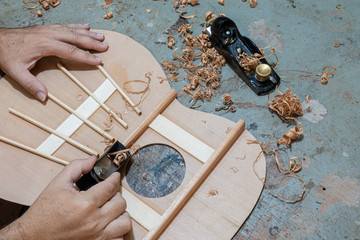 Luthier workbench with tools and a top of an acoustic guitar under construction