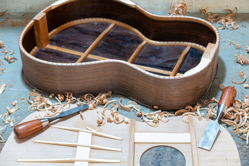 Luthier workbench with tools and an acoustic guitar under construction