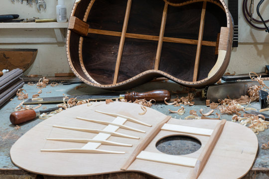 Luthier workbench with tools and an acoustic guitar under construction