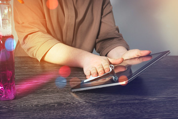The girl wipes the tablet with a blue cloth. Cleaning means for cleaning at your office Desk. The...