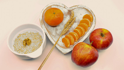 Healthy breakfast: porridge, apples. mandarin on the light background