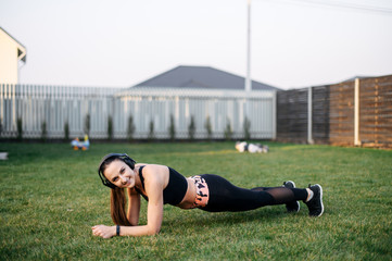 Young sporty woman is doing plank outdoors