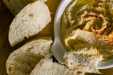 Bowl of hummus with sliced sourdough bread. 