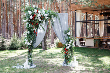Wedding arch for wedding of newlyweds. Wedding celebration outdoors in the pine forest. Wedding ceremony decoration