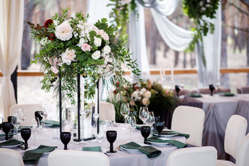Festive wedding table setting with flowers, napkins, cutlery, glasses and candles, bright summer...