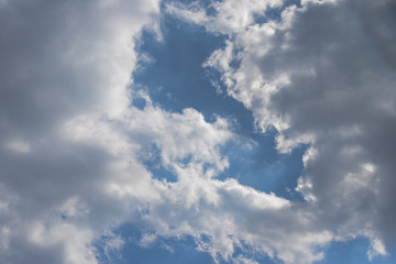Fototapeta premium Thick gray clouds with white edges on a blue sky.