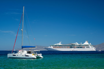Fototapeta premium Catamaran yacht and cruise liner is Aegean sea on beautiful summer day. Chora, Mykonos island, Greece