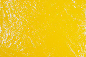 Transparent cellophane texture on an yellow backing