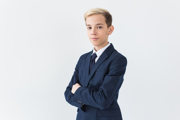 Portrait of stylish school boy teenager in white shirt and jacket against white background.