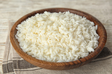 Fototapeta na wymiar Wooden bowl with cooked rice on table, closeup