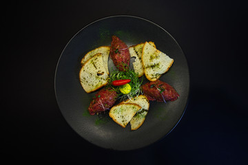 tasty food on a black background, dark background dishes of different countries, plates salads meat