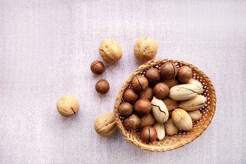Nuts in a shell in a wicker bowl on a light background