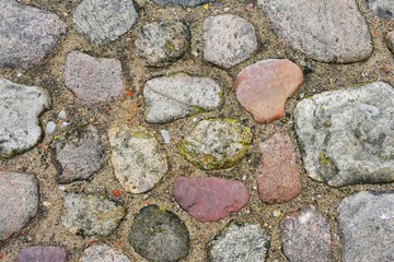 Colorful natural stone pathway. Ancient stone surface with different bricks and sand. Abstract background . 