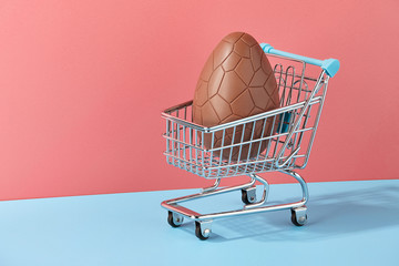 Easter chocolate egg with bow in shopping basket