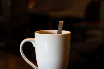 Taza de café blanca sobre fondo oscuro