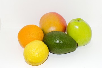 orange lemon avocado apple mango on a white wall background