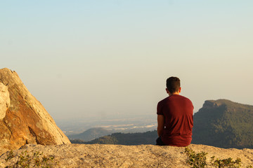 silhouette of man on top of mountain at sunset