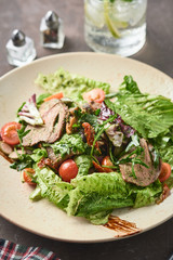 Warm salad with beef, cherry tomatoes and sun-dried tomatoes. Healthy food