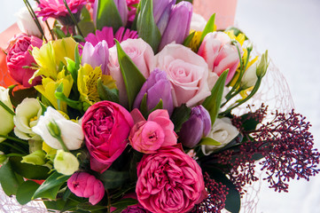 Bright roses, tulips, lilacs and other flowers in a bouquet.