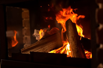 Fireplace with burning wood, closeup view. Winter vacation