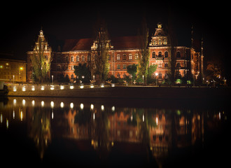 Obraz premium National Museum of Wroclaw shoted in the evening and its reflection in Odra river