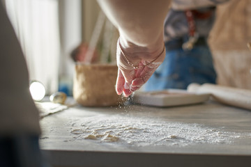 Fototapeta na wymiar a woman's hand pours wheat flour. baker's hand closeup. Cooking pizza, bread