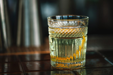 White Negroni cocktail on the bar counter. Close-up.