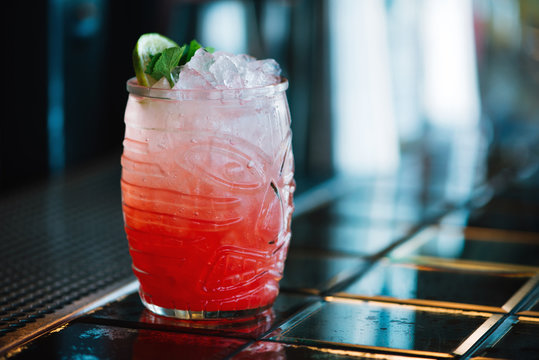 A Red Cocktail In The Tiki Glass On The Bar Counter. Close-up.