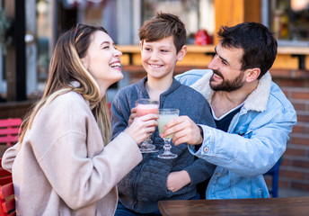 Family drinking and having fun outside in a cafe/restaurant.