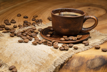 Coffee cup and coffee beans on old wooden background