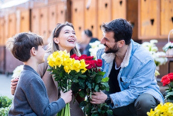 Family smiling together with flowers.