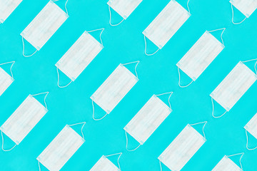 Pattern of face medical masks on blue background. Protection from coronavirus. Top view. Flat lay.